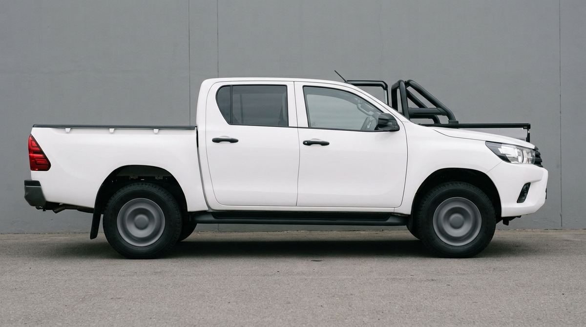 Baseline: a white Toyota Hilux double cab photographed side-on, rear passenger door undamaged.